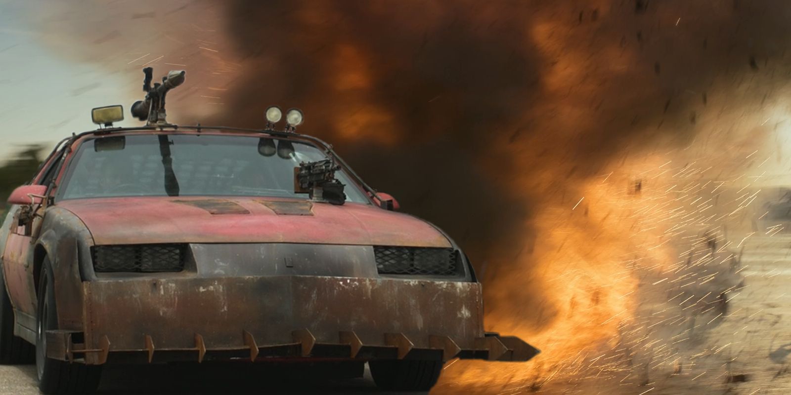 Quiet and John Doe drive Roadkill in front of an explosion in Twisted Metal.