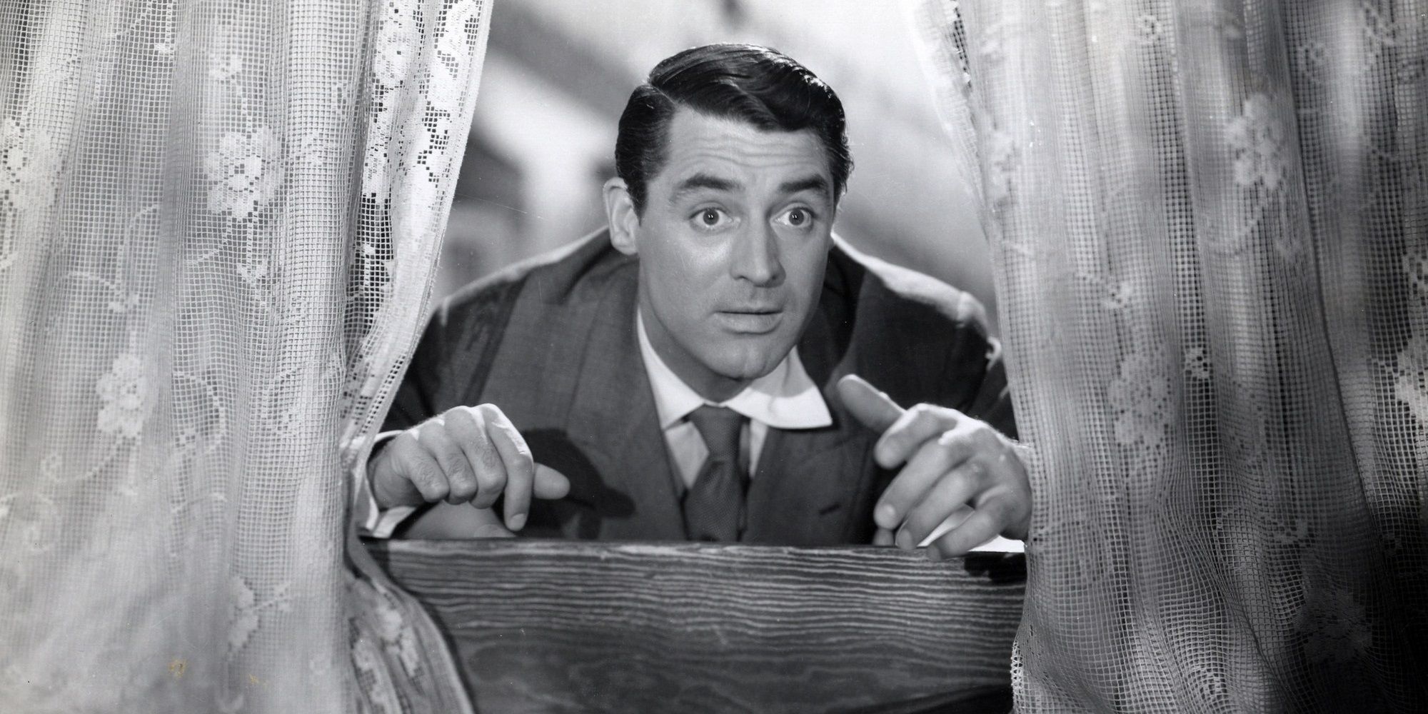 Cary Grant looks through a window in Arsenic and Old Lace