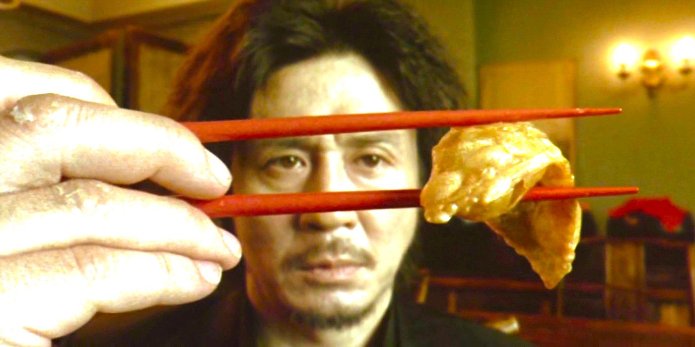 Choi Min-sik in Oldboy staring enigmatically while holding a piece of food with chopsticks