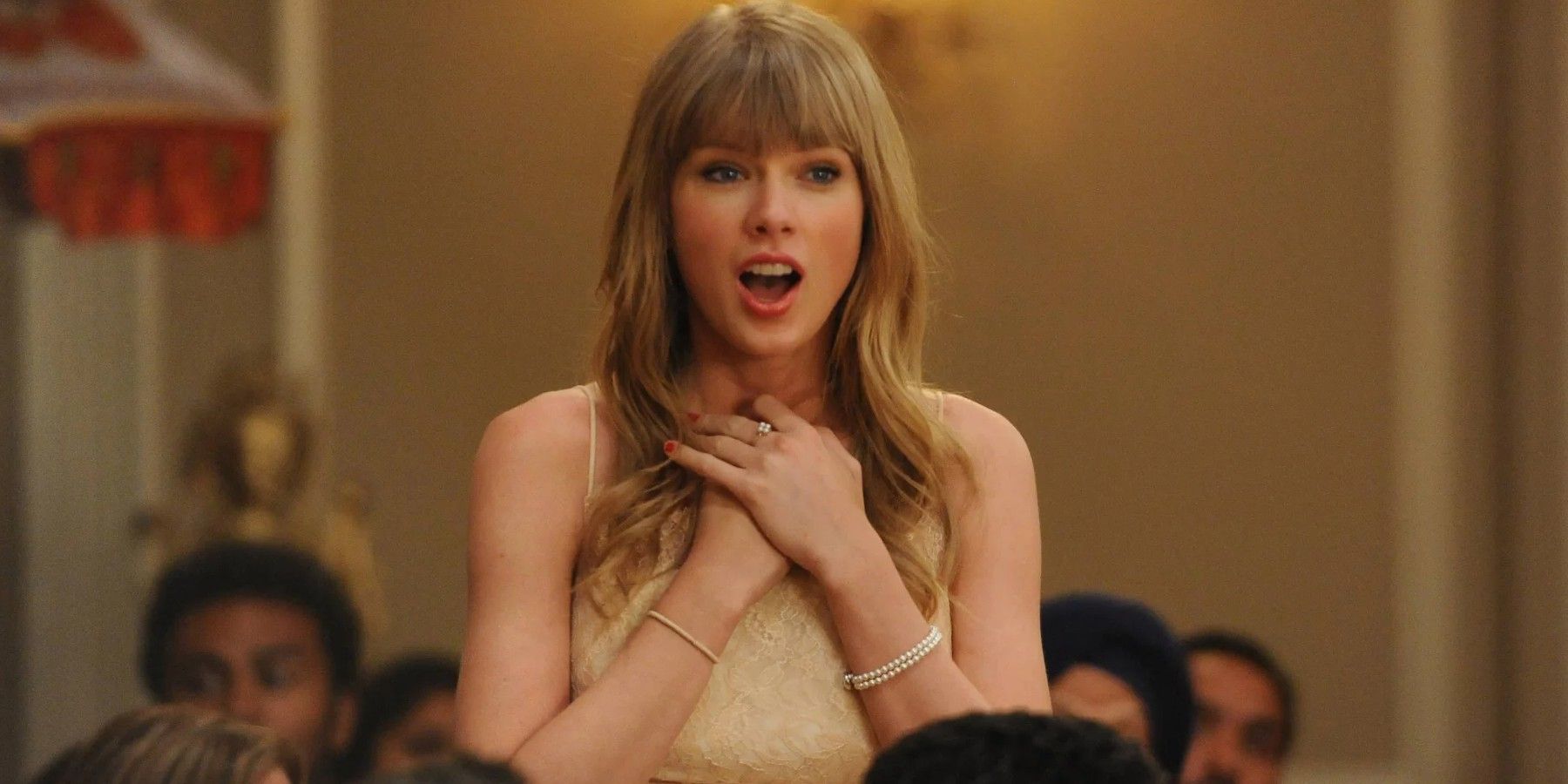 Taylor Swift' con las manos en el pecho y luciendo sorprendida en New Girl