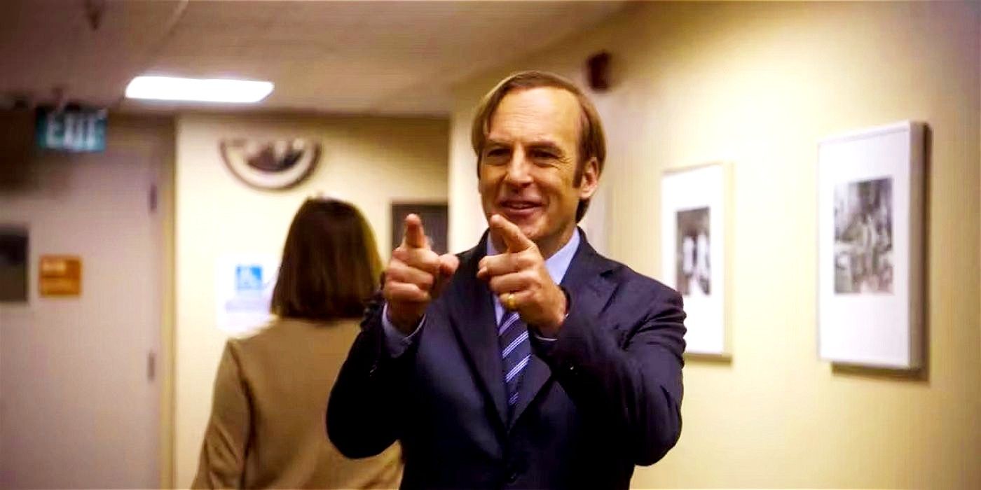 Jimmy McGill pointing both fingers and smiling, with a person walking behind him in Better Call Saul