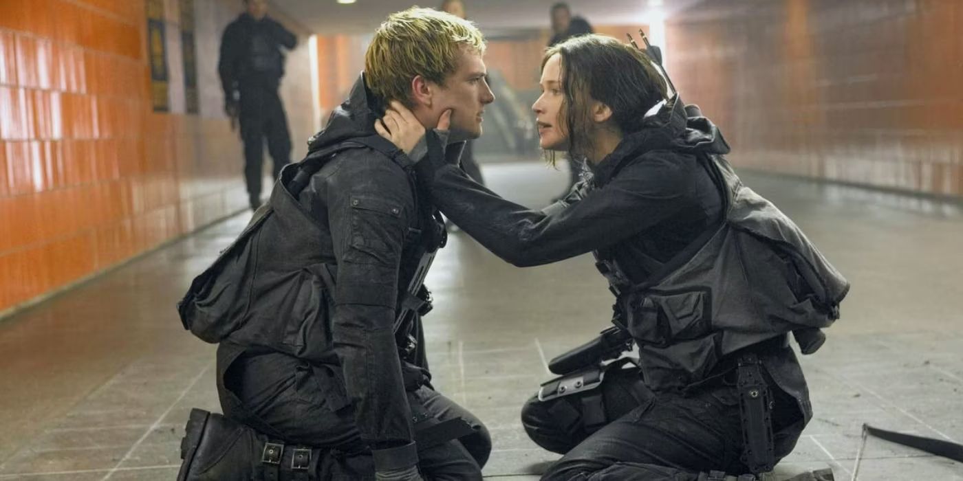 كاتنيس وبيتا راكعين على البلاط في فيلم The Hunger Games: Mockingjay