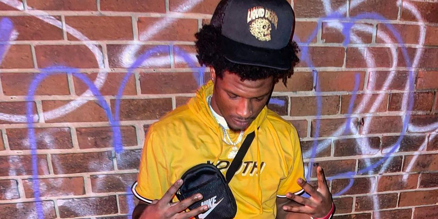Keenan Anunay Love Island USA Season 5 wearing yellow posing near brick wall