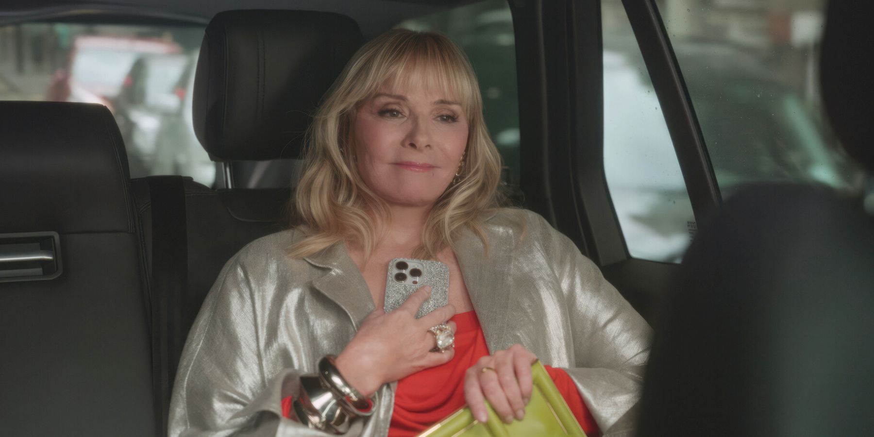 Kim Cattrall como Samantha Jones sonriendo en un taxi en And Like It Temporada 2