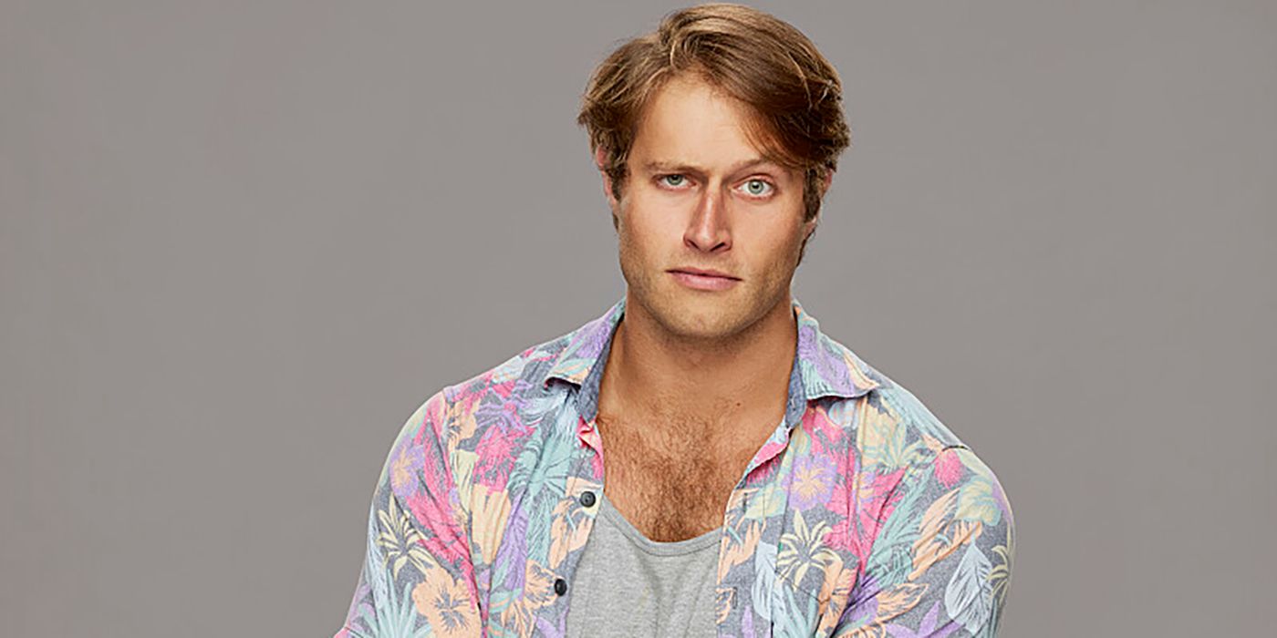 Luke Valentine from Big Brother wearing print shirt and not smiling, against a gray background