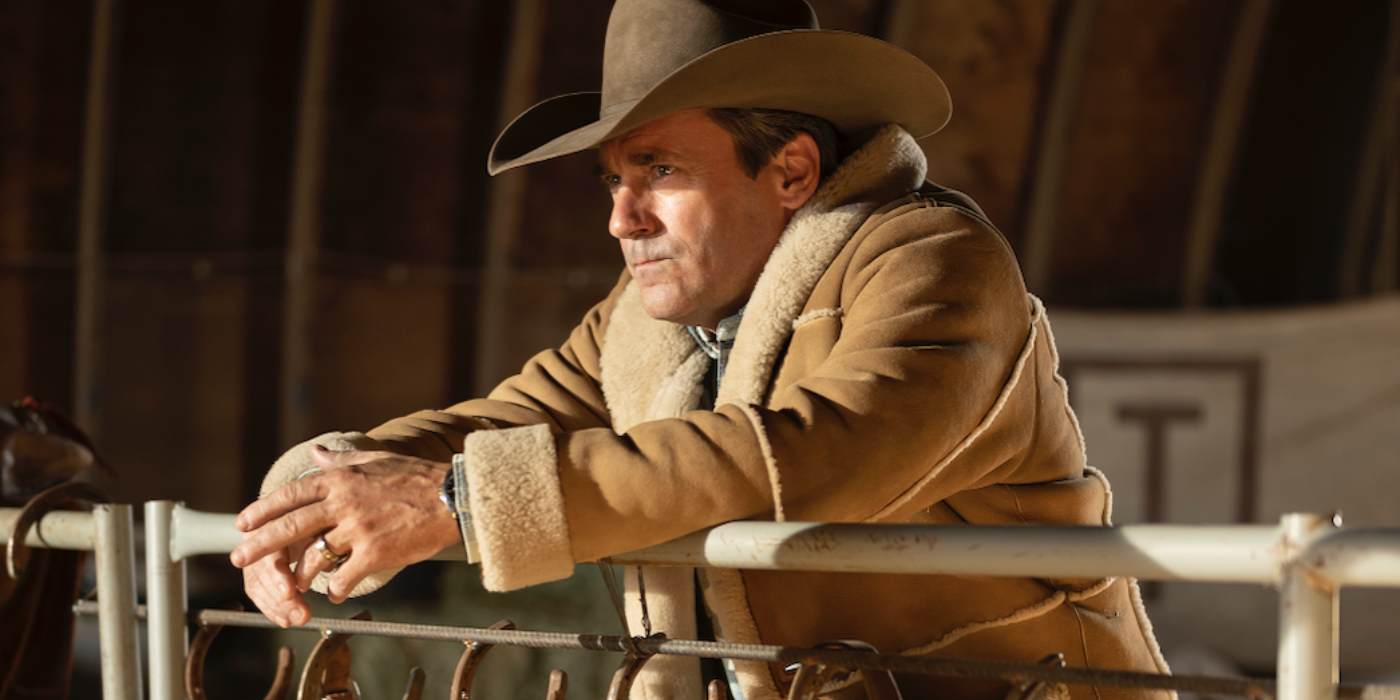 Jon Hamm wearing a cowboy hat leaning against a fence in Fargo.