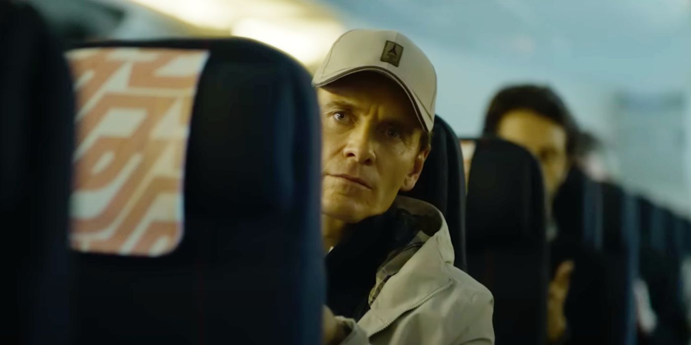 Michael Fassbender wearing a baseball cap on a plane in The Killer.