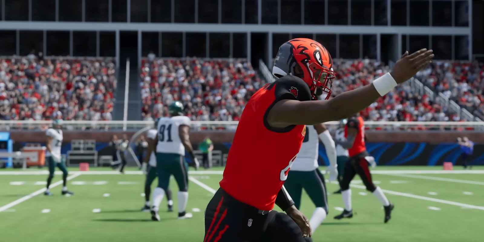 Football player in custom orange uniform pointing down field.