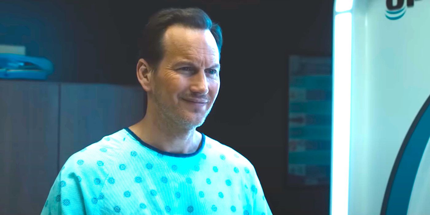Patrick Wilson in Insidious The Red Door wearing a hospital gown and smiling somewhat smugly