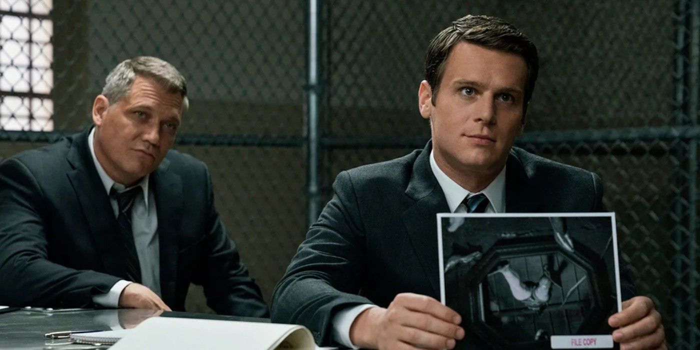 Jonathan Groff como Holden Ford segurando uma foto e Holt McCallany como Bill Tench em Mindhunter