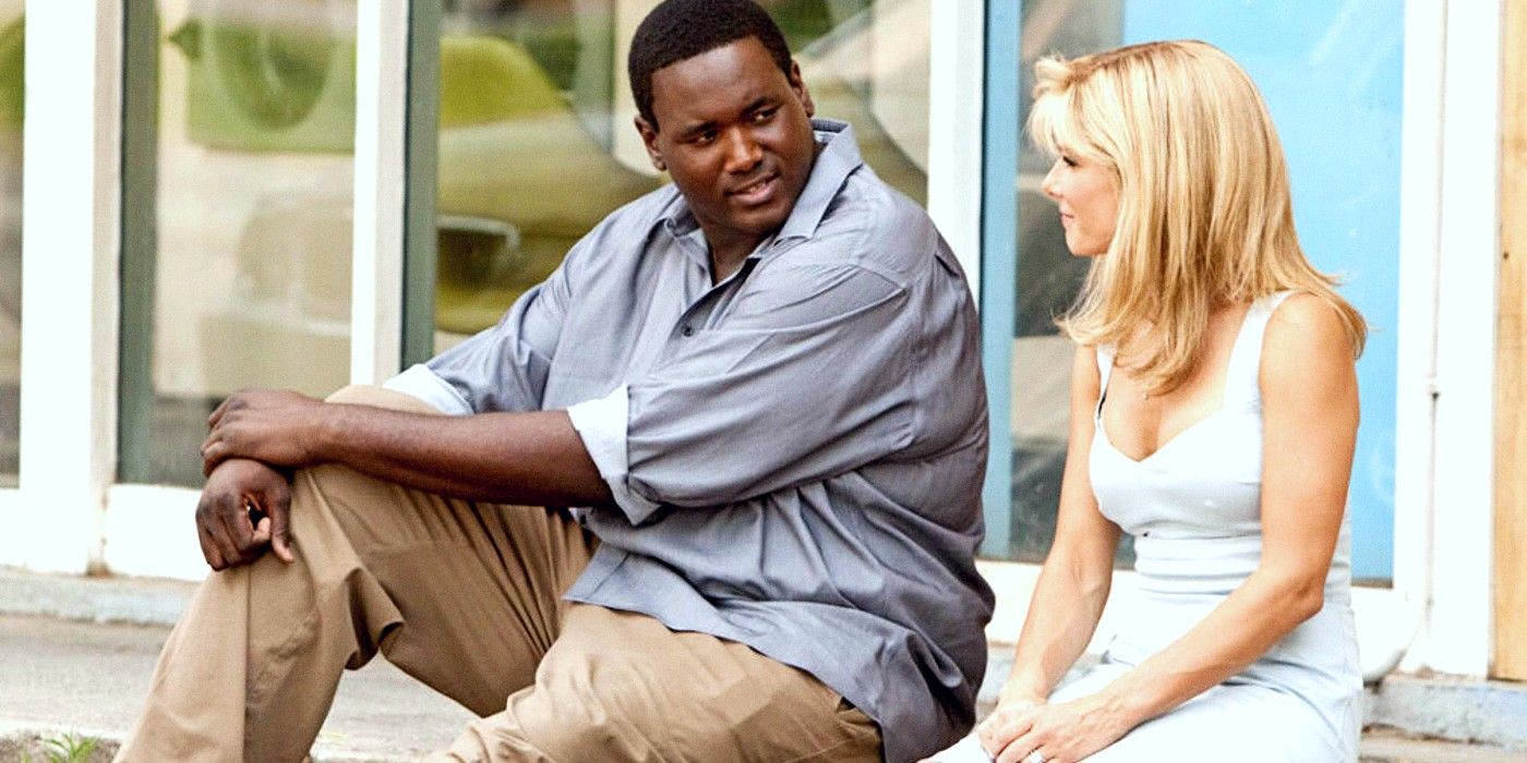 Quinton Aaron and Sandra Bullock sitting together on steps in The Blind Side