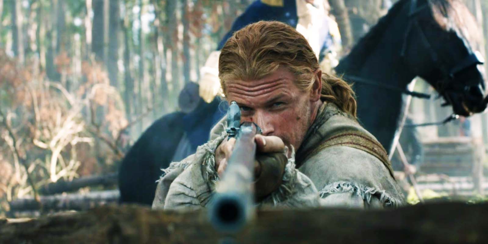 Sam Heughan as Jamie Fraser pointing a gun at the screen in Outlander season 7 midseason finale