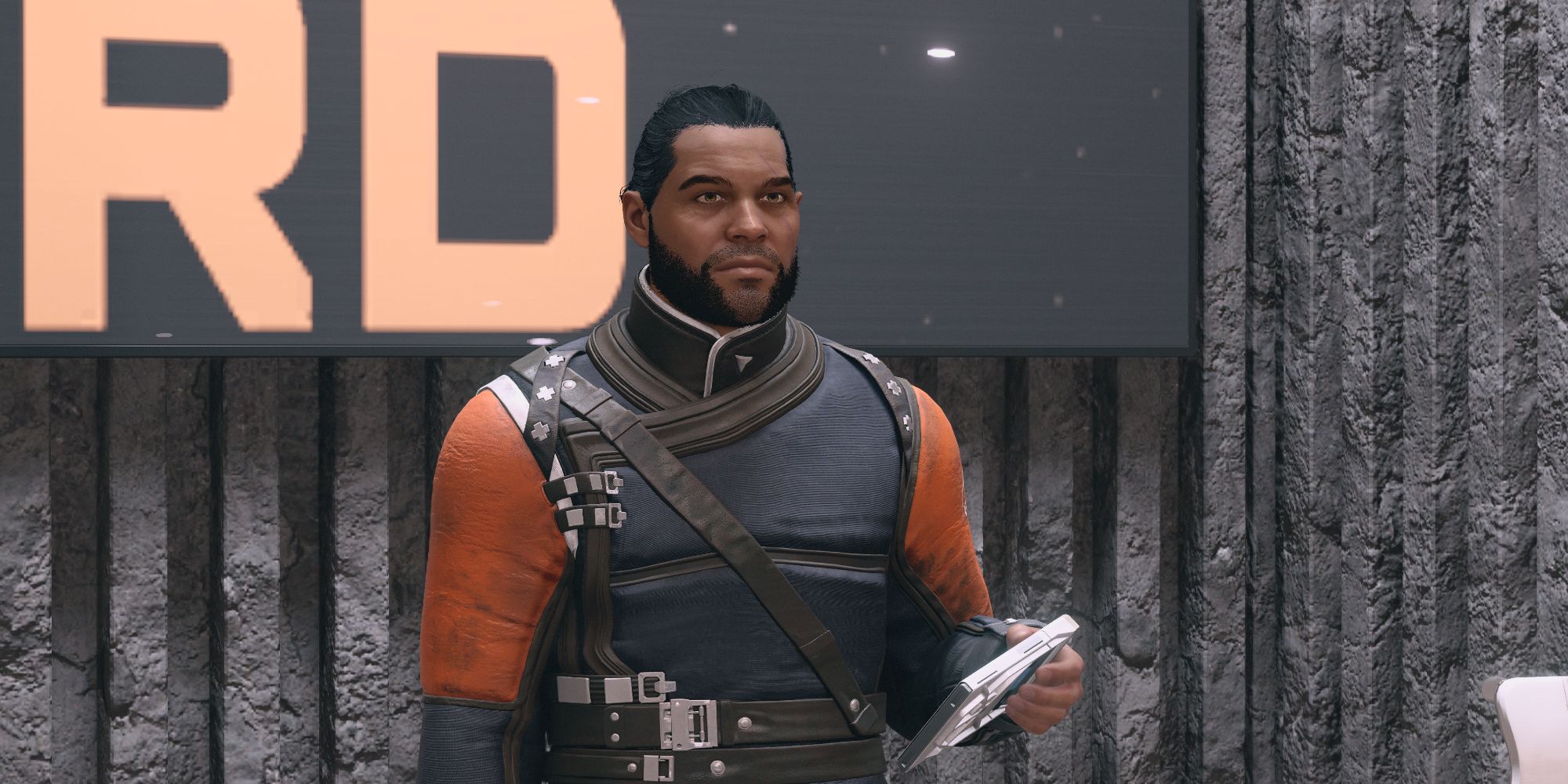 Commander Tuala in Starfield, standing behind a desk and holding a slate in his left hand.
