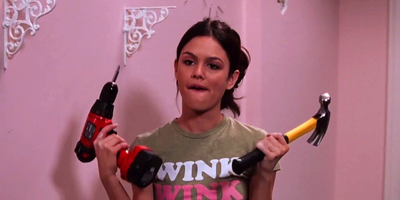 A scene from The O.C. where Summer is making a silly face while holding a drill in one hand and a hammer in the other.