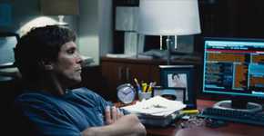 Michael Burry (Christian Bale) looking at computer monitors in The Big Short