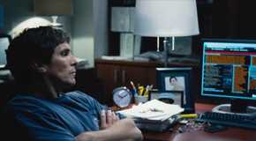 Michael Burry (Christian Bale) looking at computer monitors in The Big Short