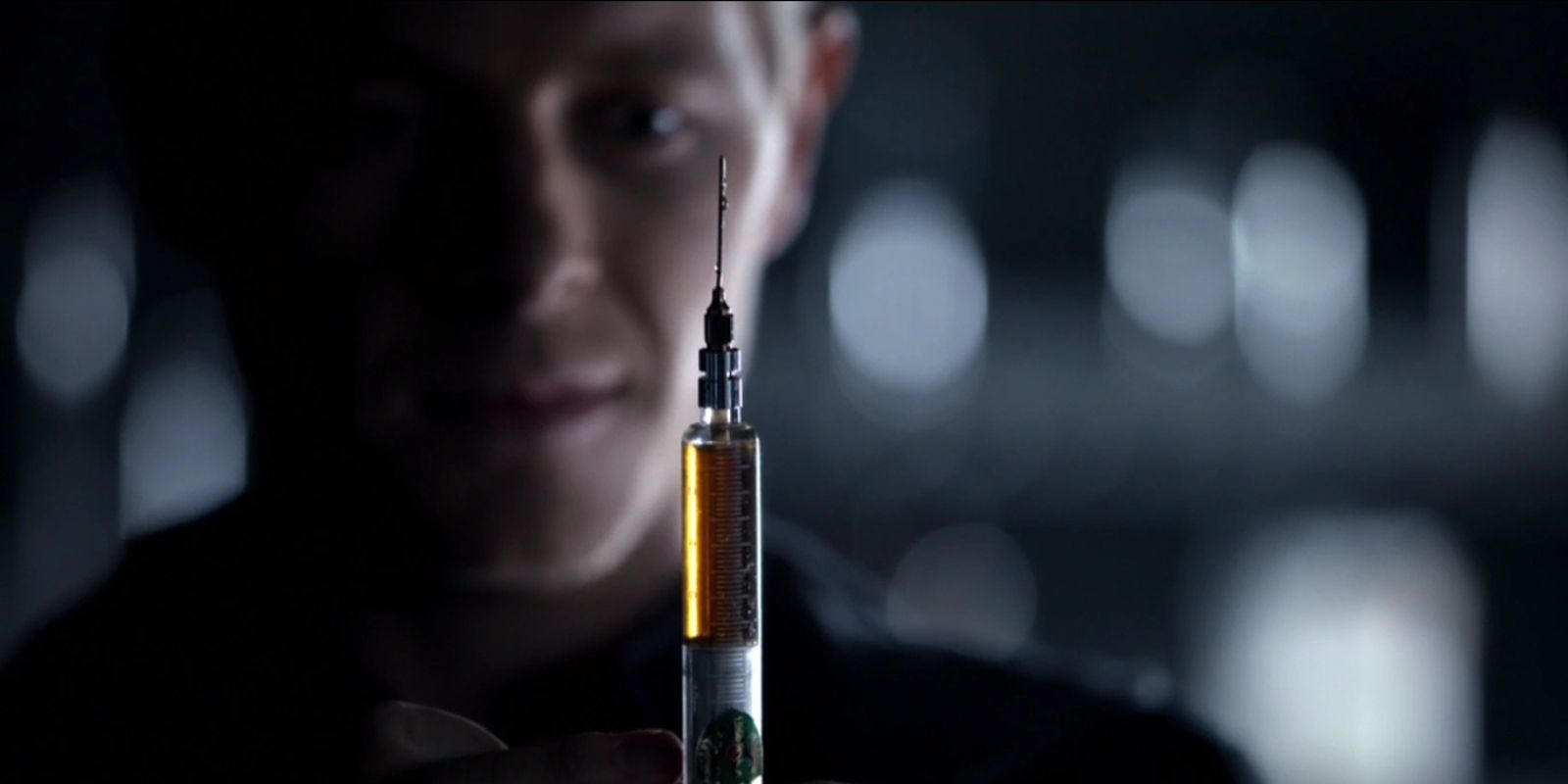 Dr. Maxfield holds up a needle filled with the Ripper Virus serum.