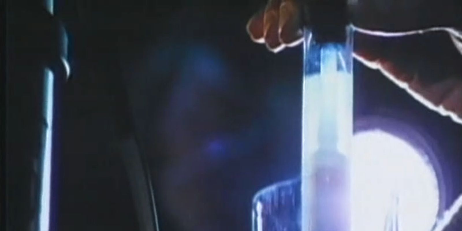 A hand holds up a vial of the MM88 virus.