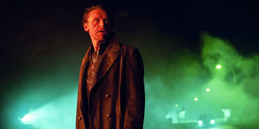 Simon Pegg as Gary King standing outside with green mist behind him in The World's End