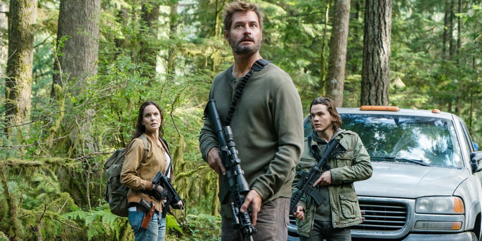 Three characters in the woods with guns in Colony