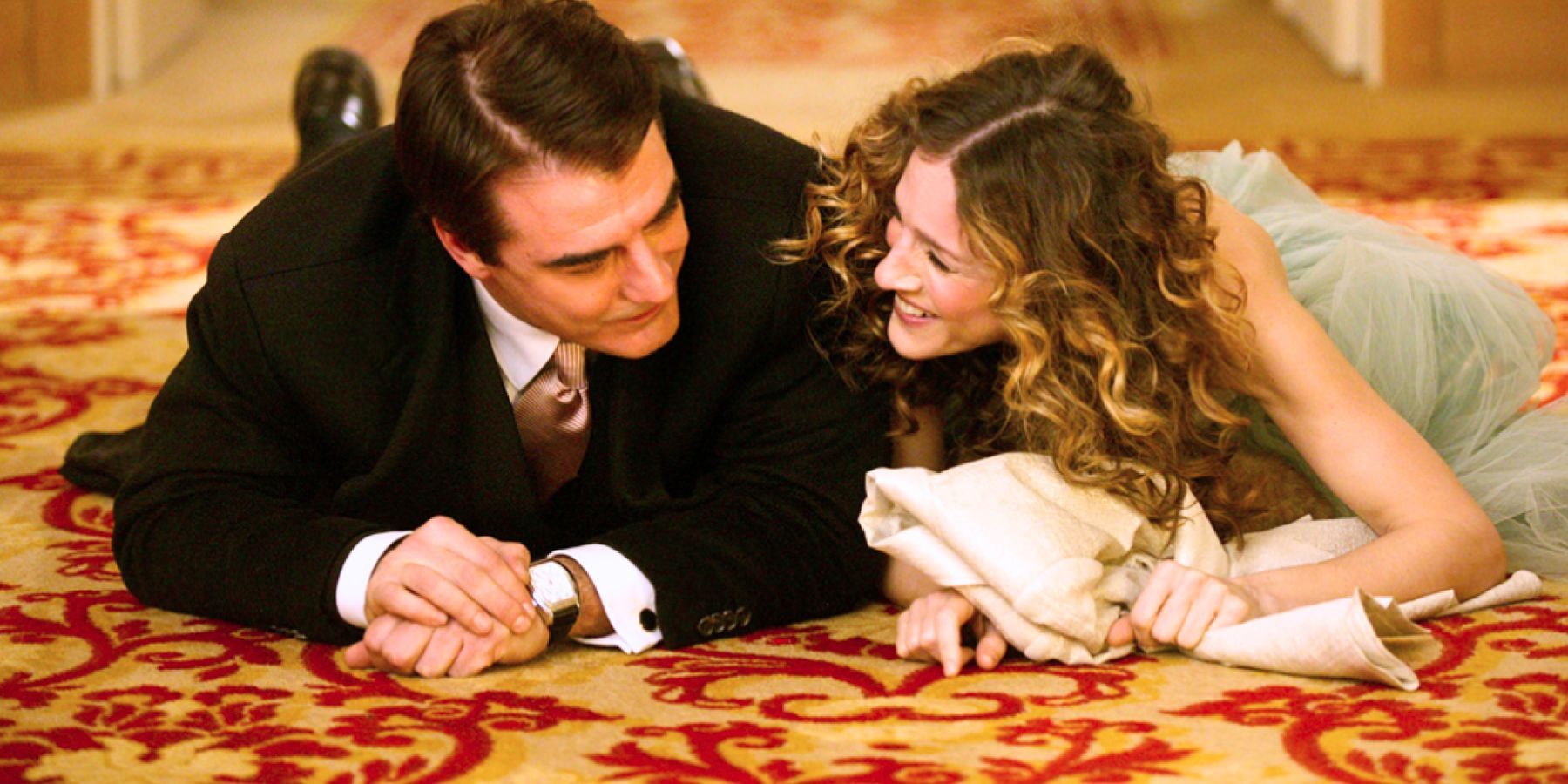 Big and Carrie Bradshaw smiling after falling to the floor in the hallway of a hotel in Paris