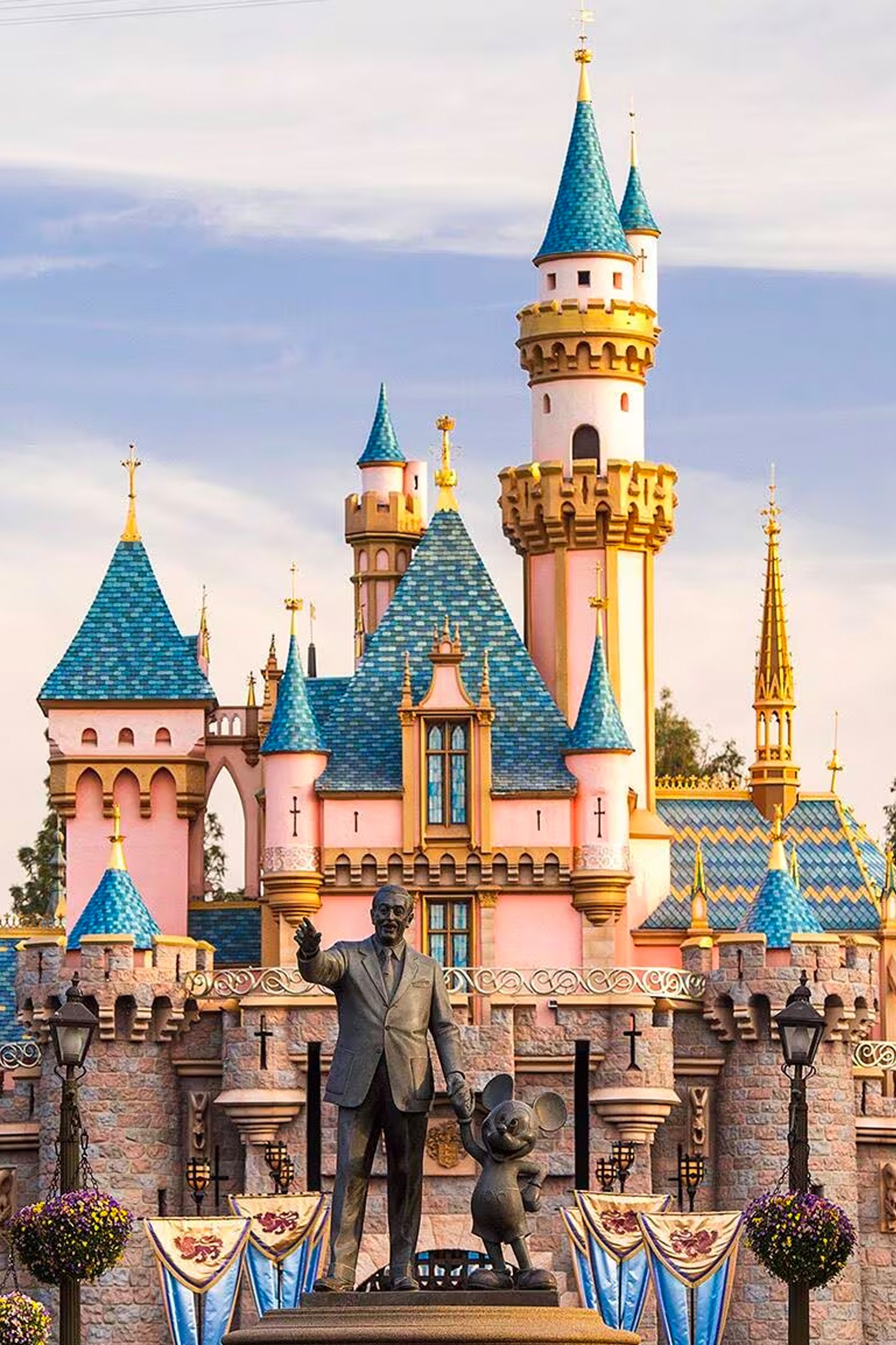 Walt Disney in front of Disneyland Castle
