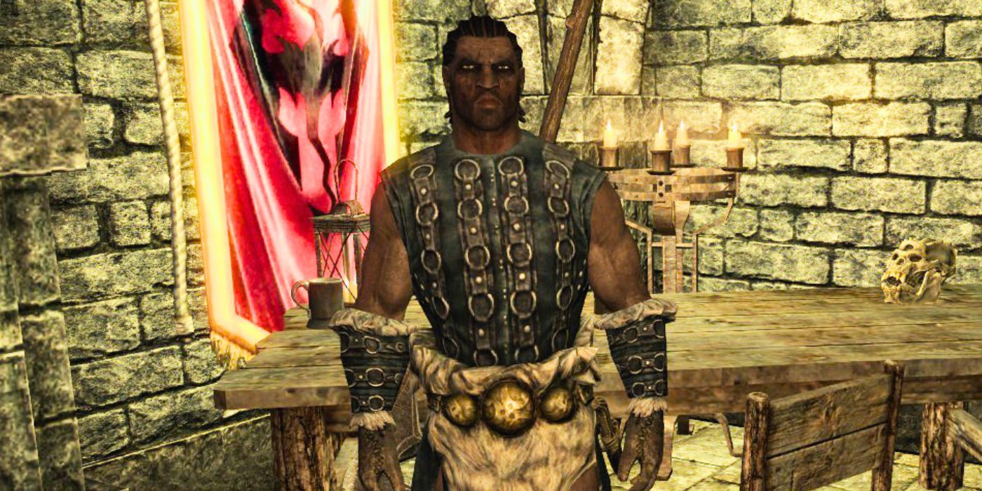 Ahtar in Skyrim, standing in front of an Imperial flag with a mean expression.