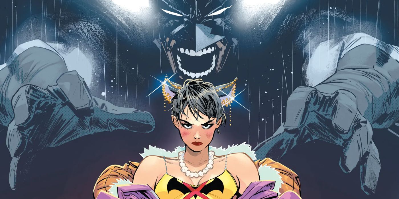 Batman stands behind Catwoman wearing a shirt of a bat with an X through it