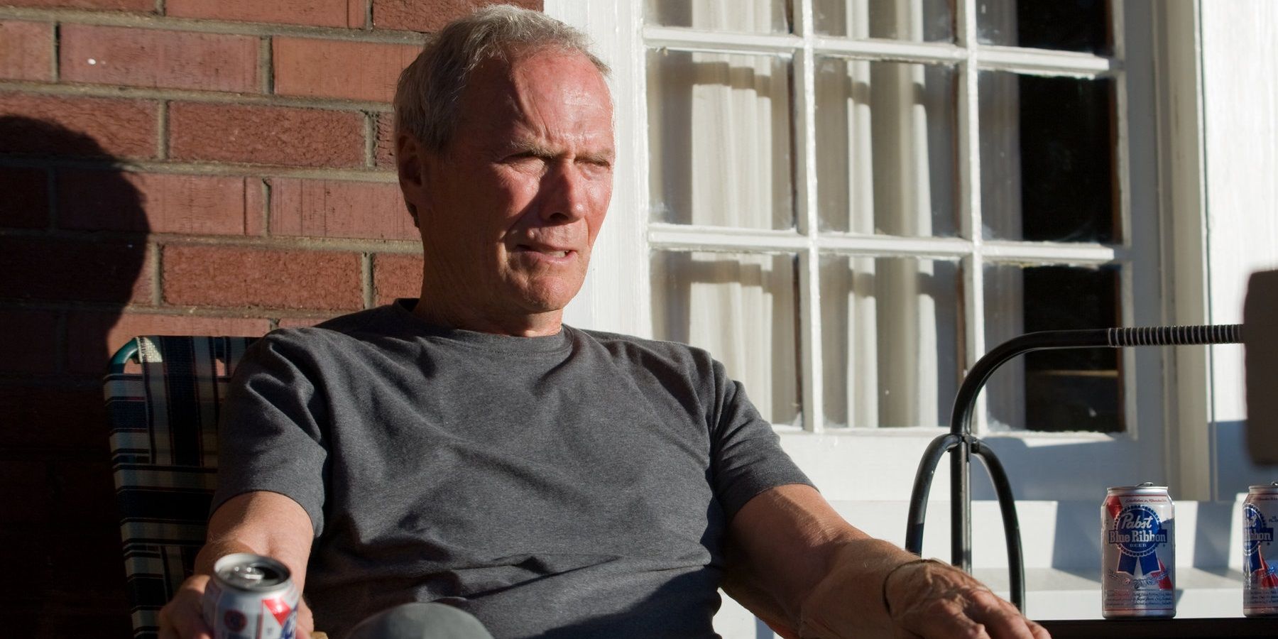 Clint Eastwood sitting on a veranda in Gran Torino