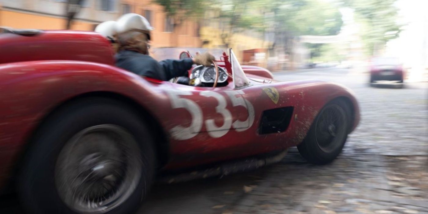 A red Ferrari speeding through a street in Ferrari