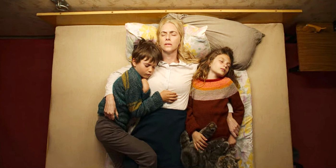 Imagen fija del episodio 1 de Dear Child en Netflix con una mujer y dos niños acostados en una cama vistos desde arriba.