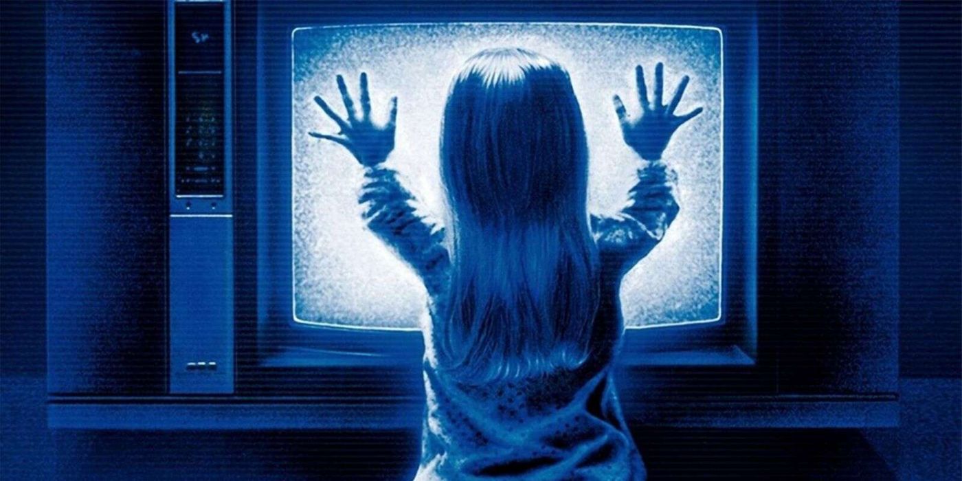 Heather O'Rourke as Carol Anne with her hands on the TV in Poltergeist