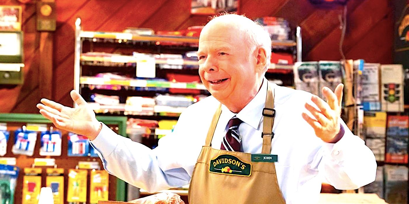 Dr Sturgis smiling in an apron and raising his hands in Young Sheldon