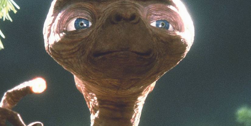 E.T. holds up a glowing finger in E.T. the Extra-terrestrial.