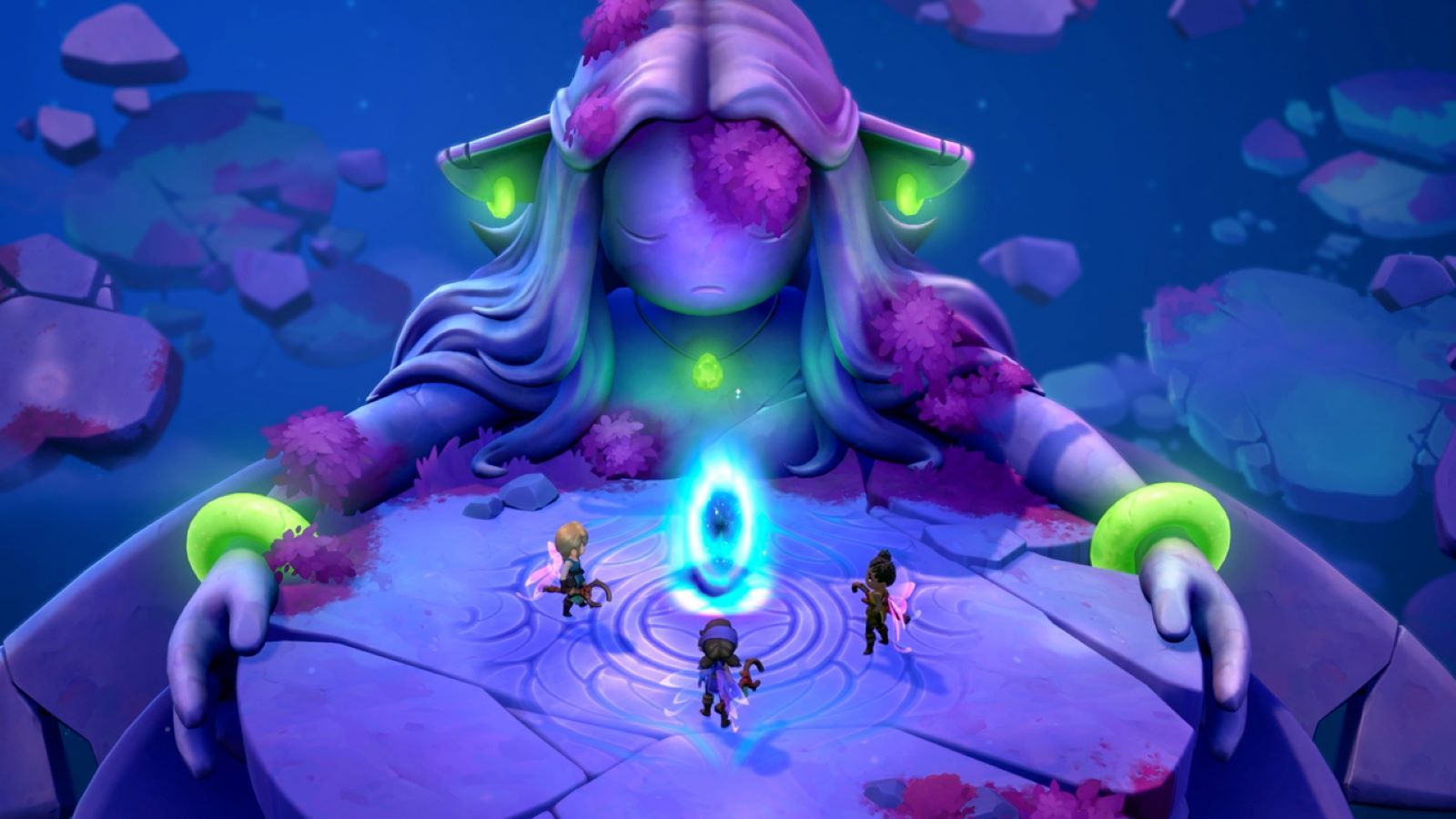 A group of players stand before a large statue with green jewelry and purple moss