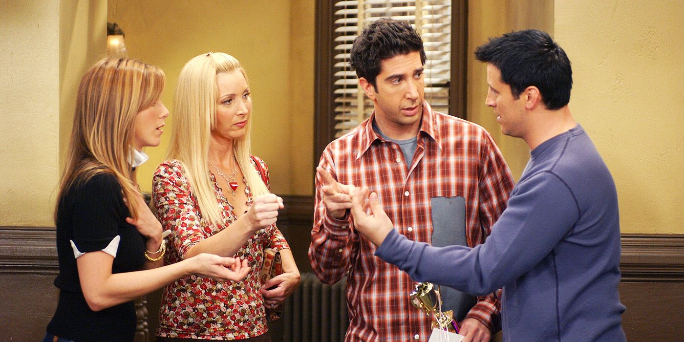 Jennifer Aniston, Lisa Kudrow, David Schwimmer, and Matt LeBlanc as Rachel, Phoebe, Ross, and Joey talking in the hallway in Friends