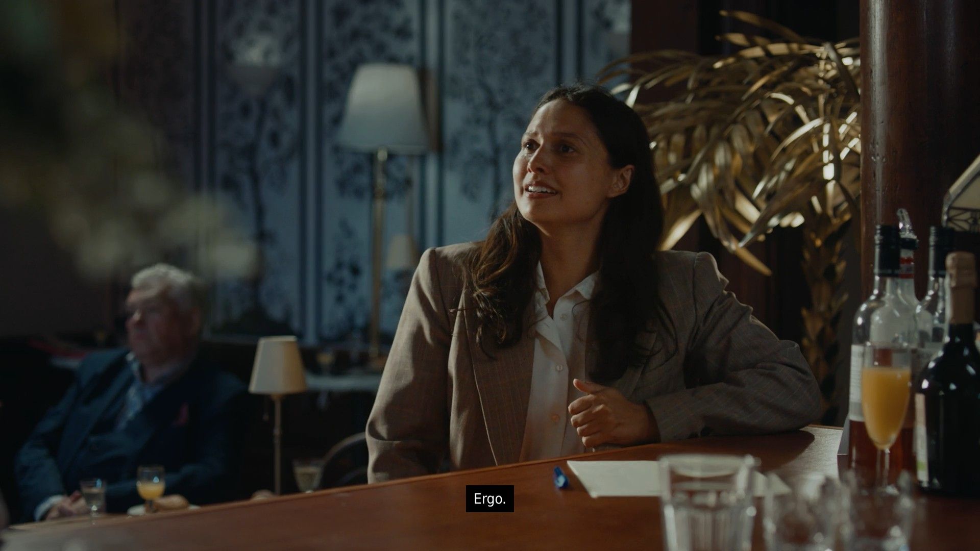 Isle Tide Hotel female actress in a suit saying “Ergo” and crying.