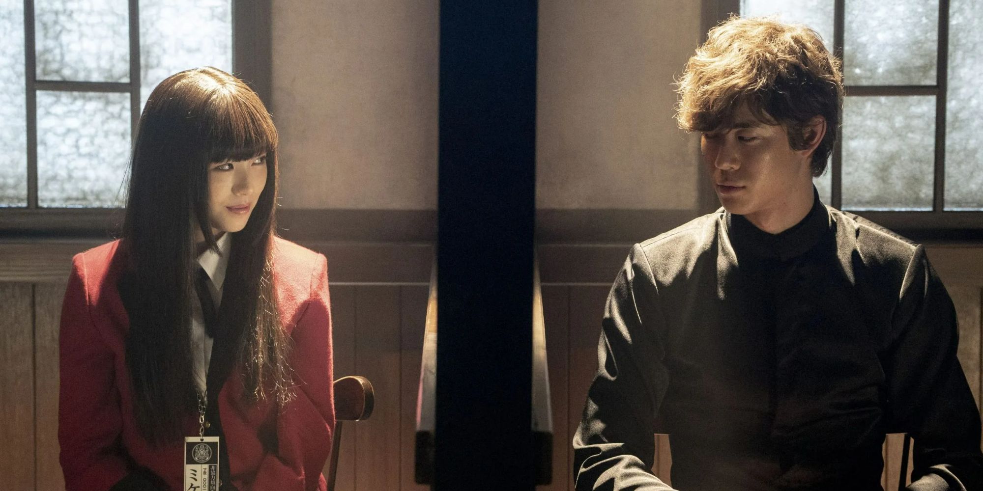 a teenage girl smirks at a teenage boy next to her in the live-action Kakegurui