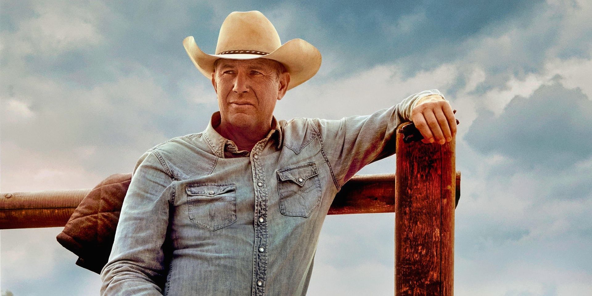 Kevin Costner leaning against a fence in Yellowstone