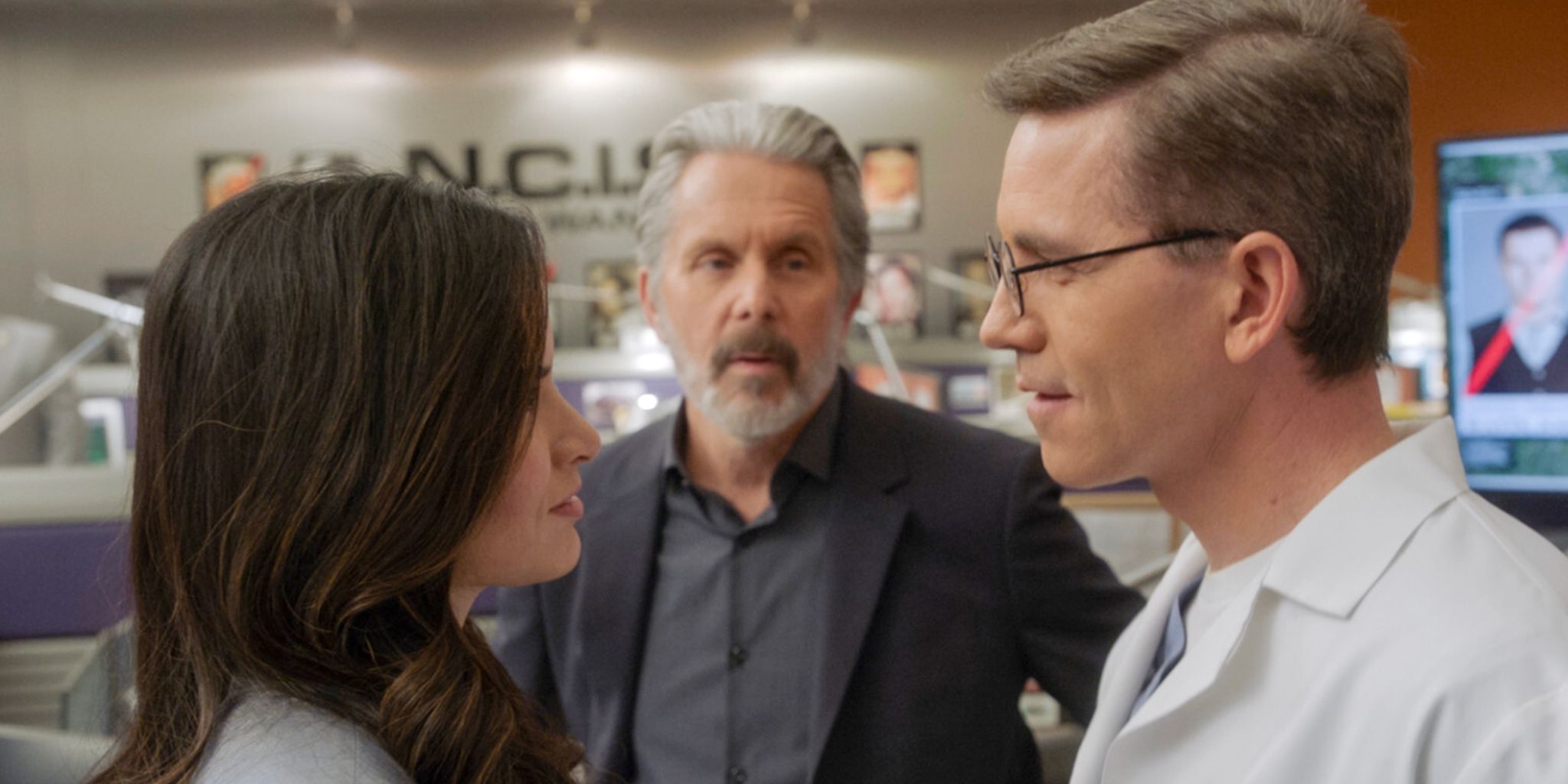 Knight and Palmer talking in front of Parker in NCIS