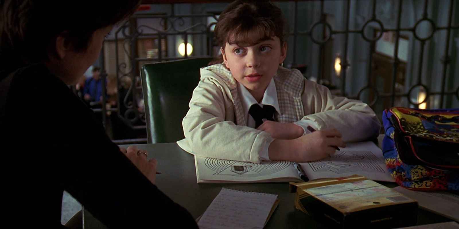 Lily colors with a crayon while talking to Detective Benson.