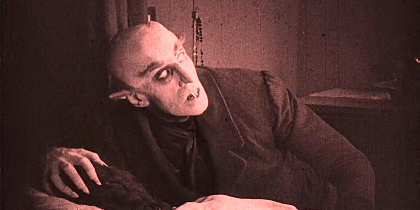 Max Schreck looming over his victim in Nosferatu 1922