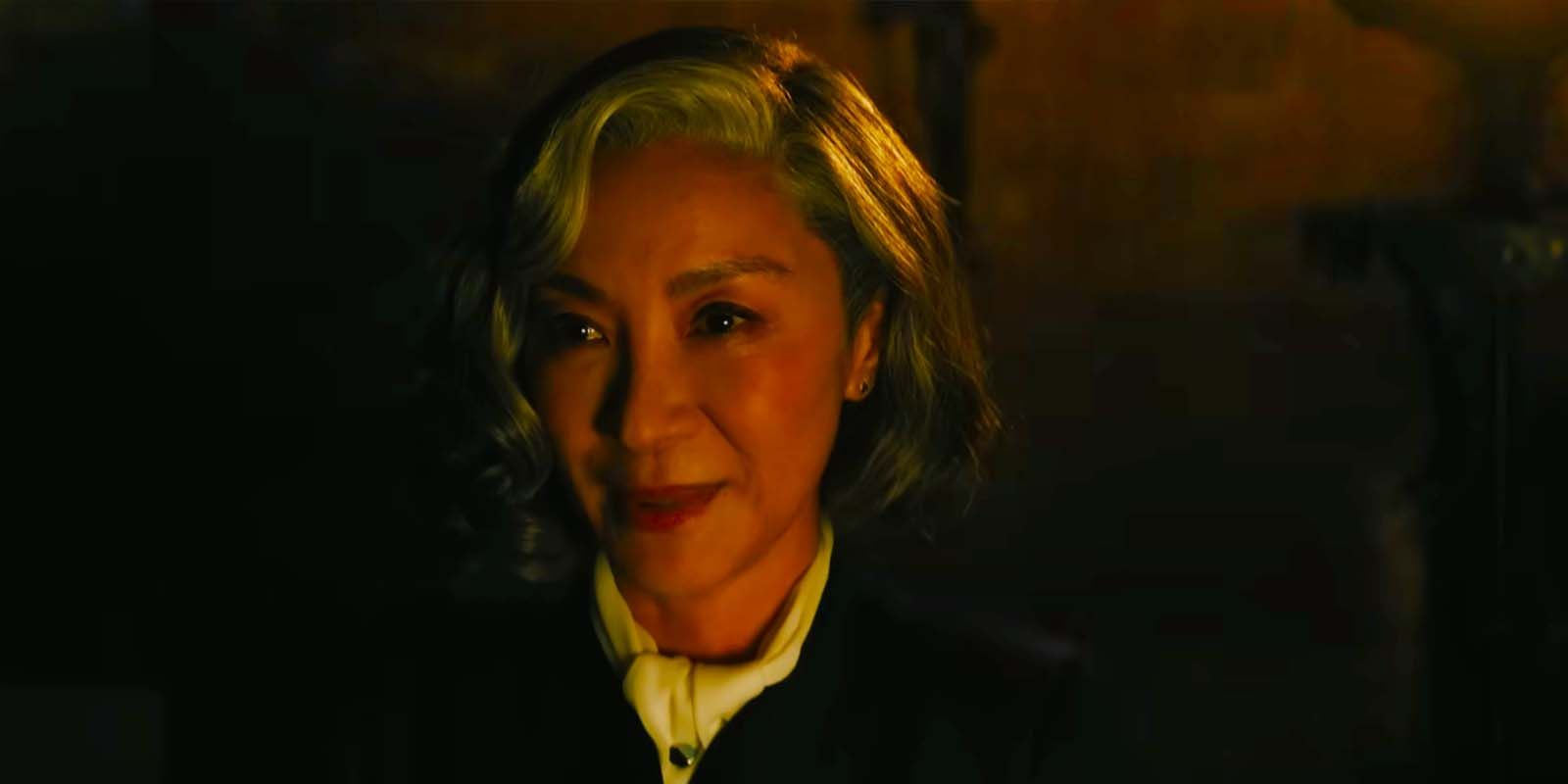 Michelle Yeoh smiling as Mrs. Reynolds in A Haunting in Venice