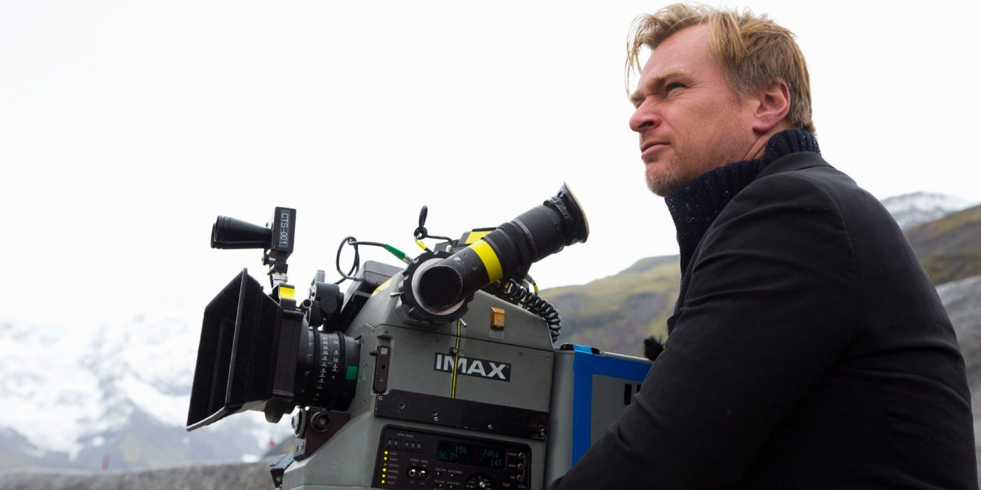 Christopher Nolan seated next to an IMAX camera during the filming of one of his movies