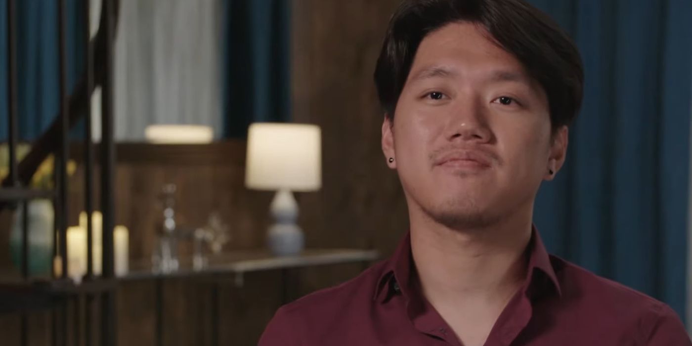 Nick 90 Day Fiance talking to cameras dark background red shirt