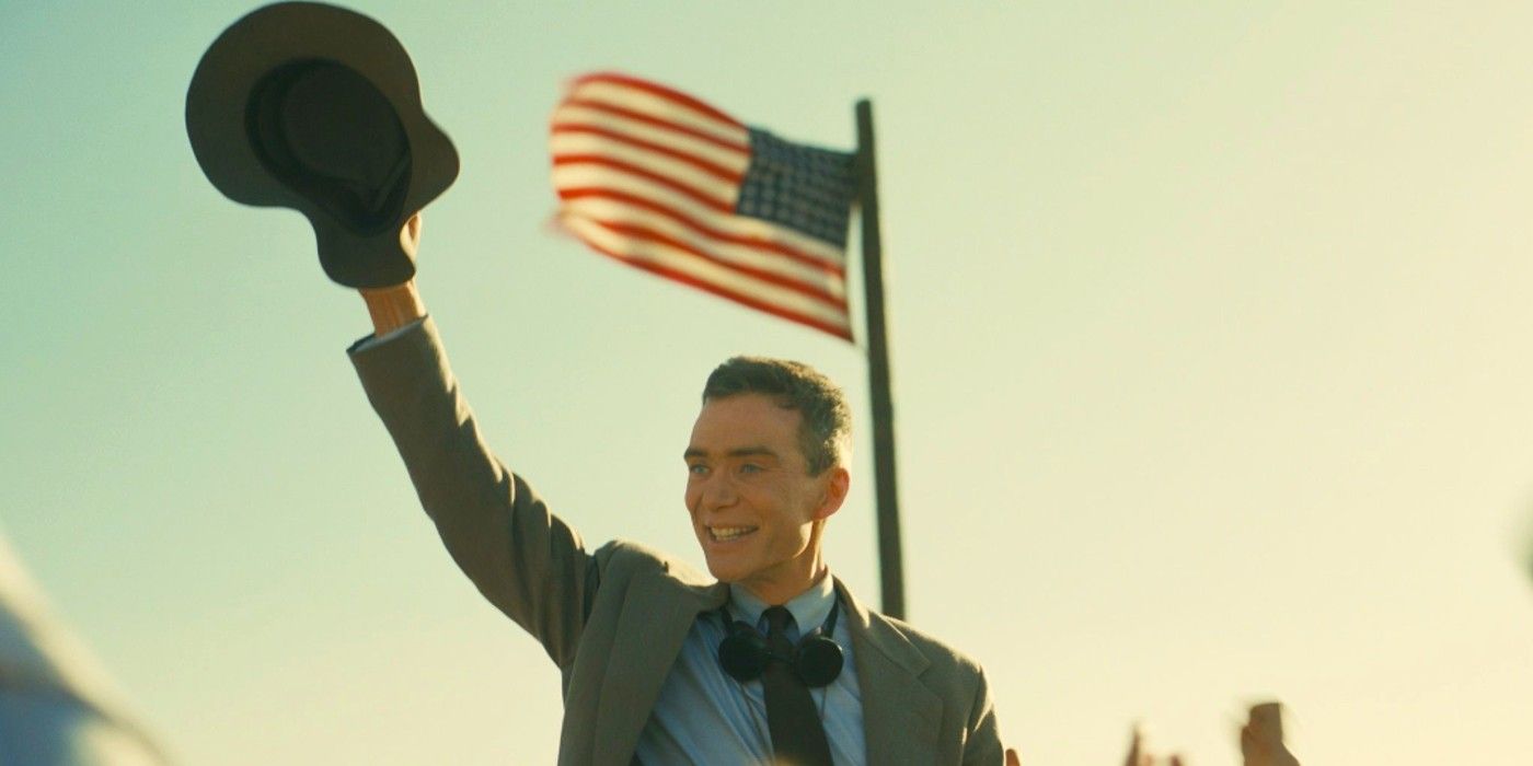 Cillian Murphy como J. Robert Oppenheimer comemora diante de uma bandeira americana em Oppenheimer.