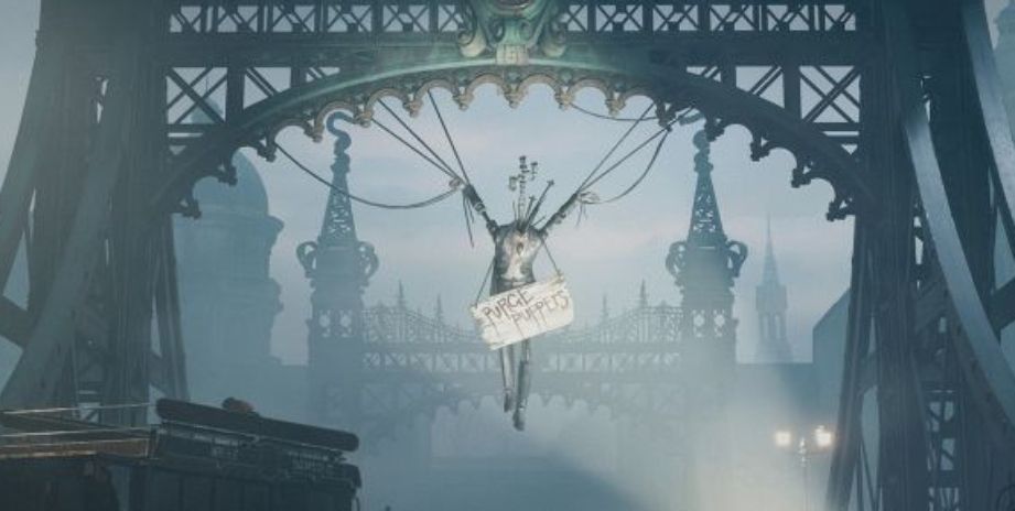 A decapitated puppet dressed in a suit with knives sticking out of its neck hangs by the wrists from a bridge arch. A wooden sign dangles off its shoulders, reading 