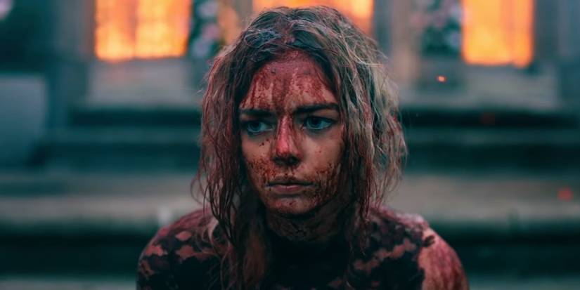 Grace sits in front of a burning house while drenched in blood in the ending of Ready or Not