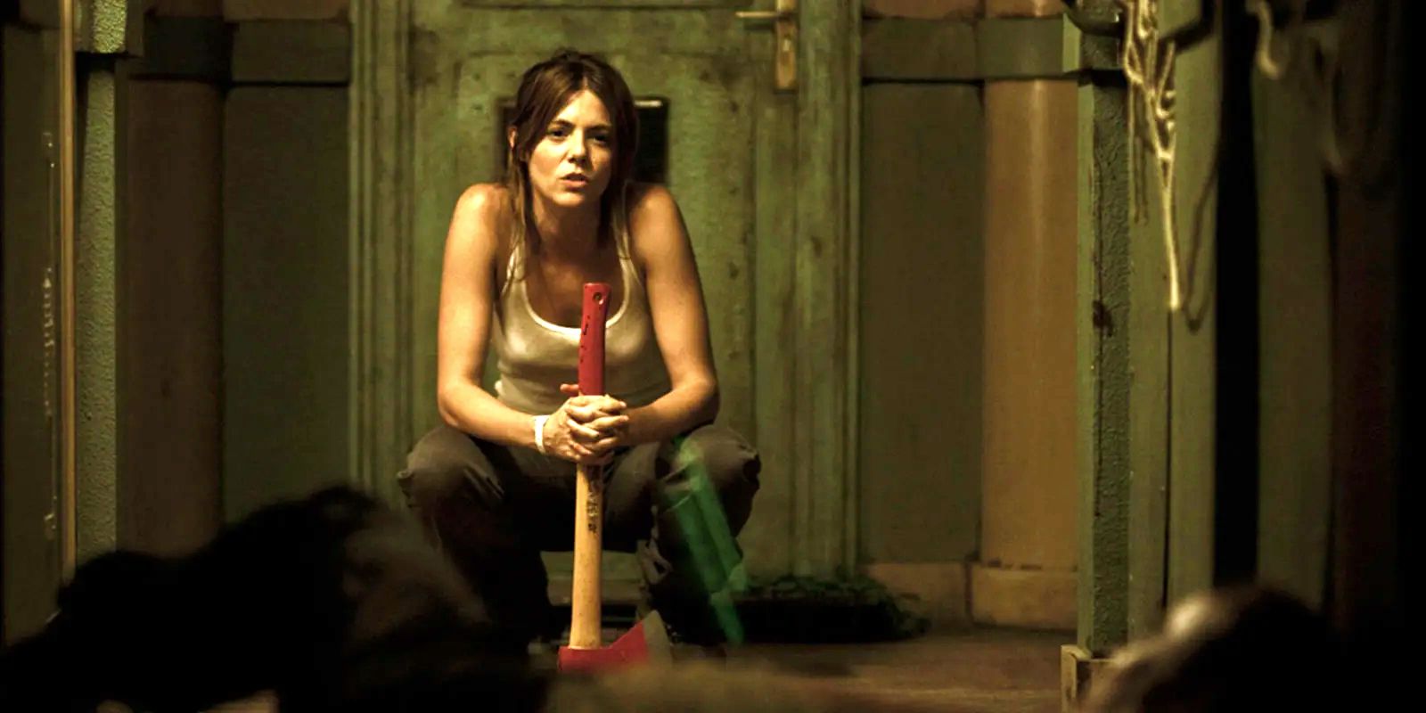 Angela crouches down with an ax in her hand in Rec 4