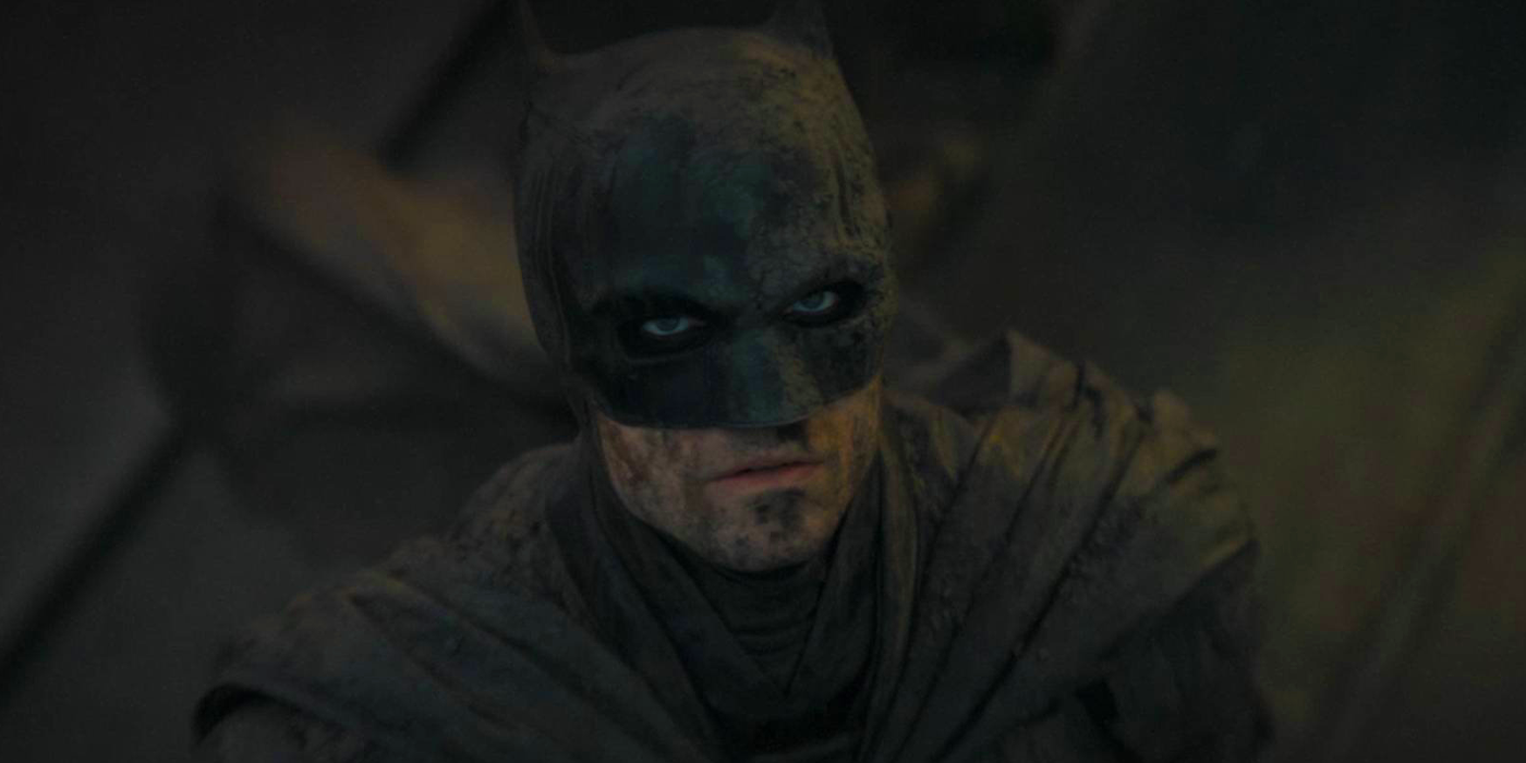 Robert Pattinson as Batman looking up and covered in mud in 2022's The Batman